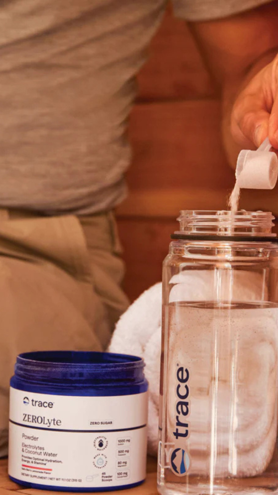 A Person Pouring Trace Electrolyte Powder Into Their Water Bottle